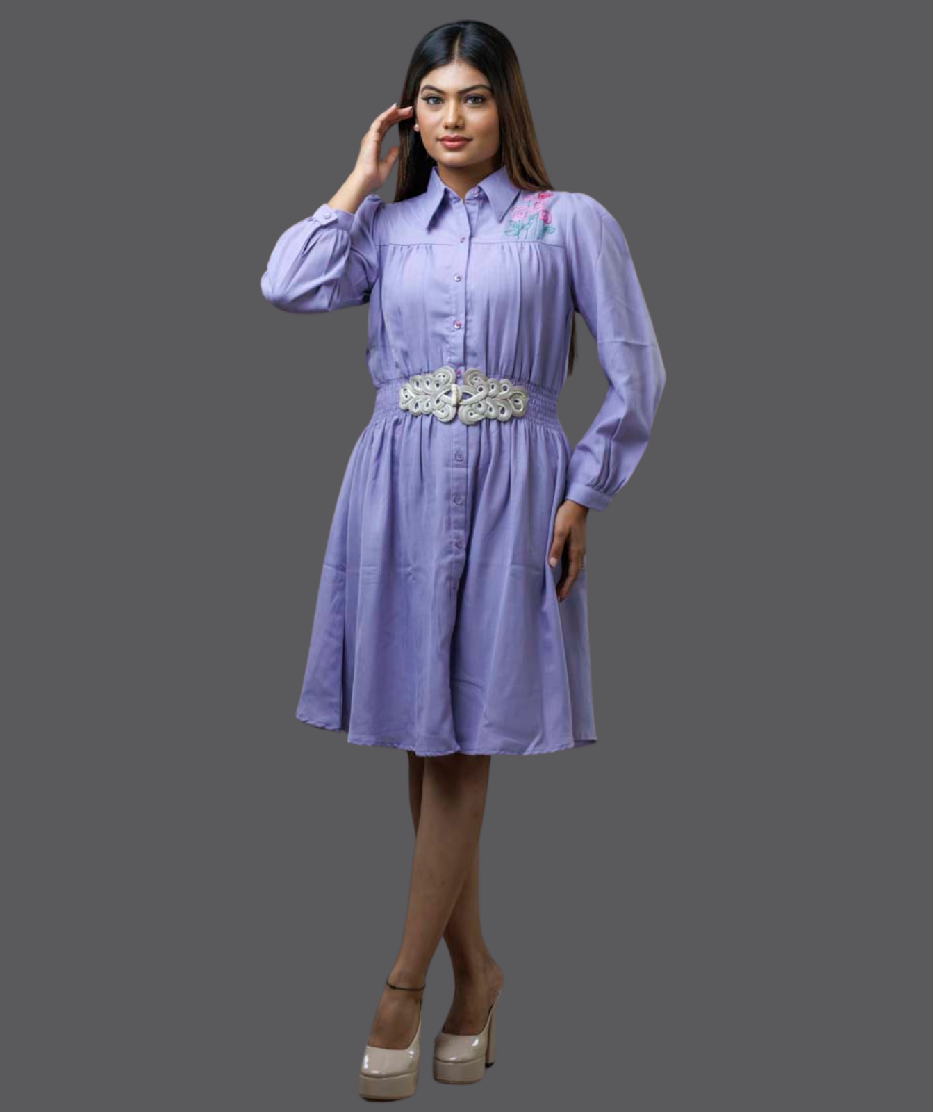 Woman wearing a light purple dress with a belt on a gray background
